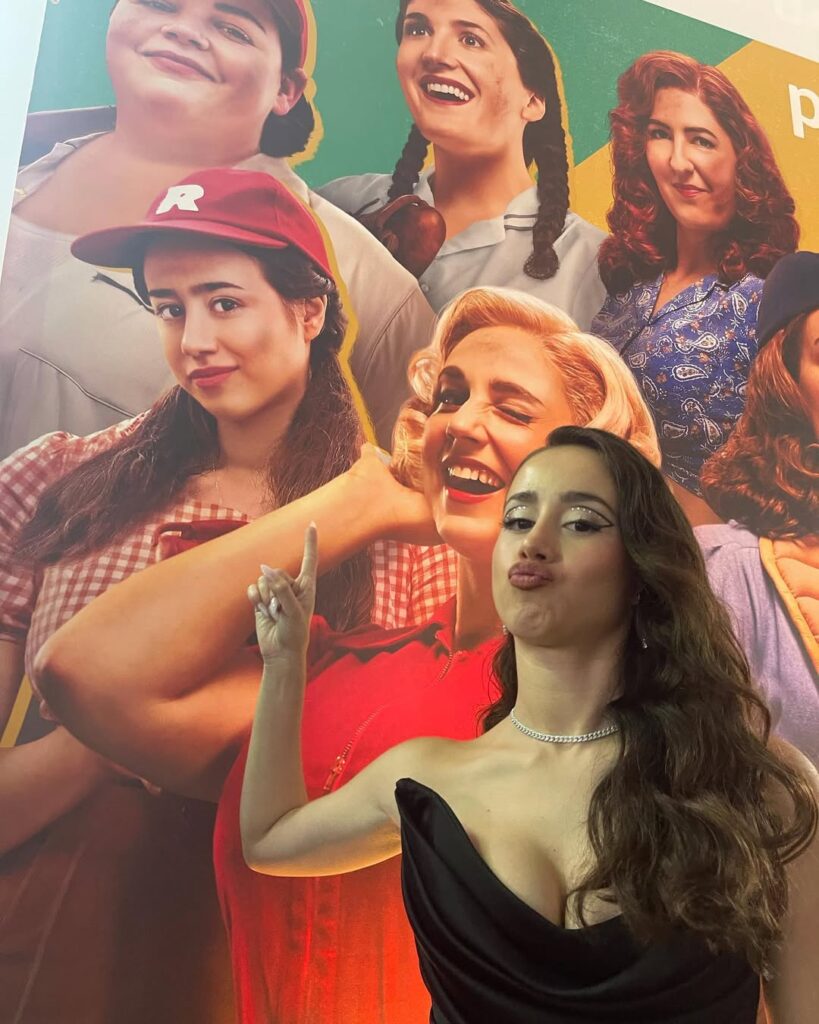 Priscilla Delgado pouting and showing her amazon prime series poster